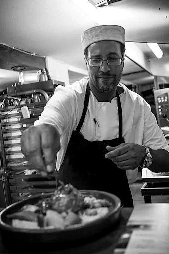 Le chef du restaurant dressant un plat en cuisine